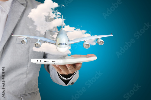 Business man holding tablet present airplane in his hand