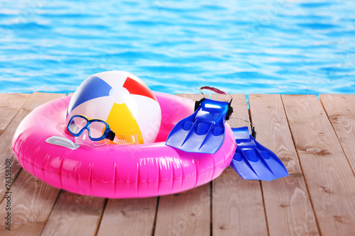 Bright beach accessories on pool background photo