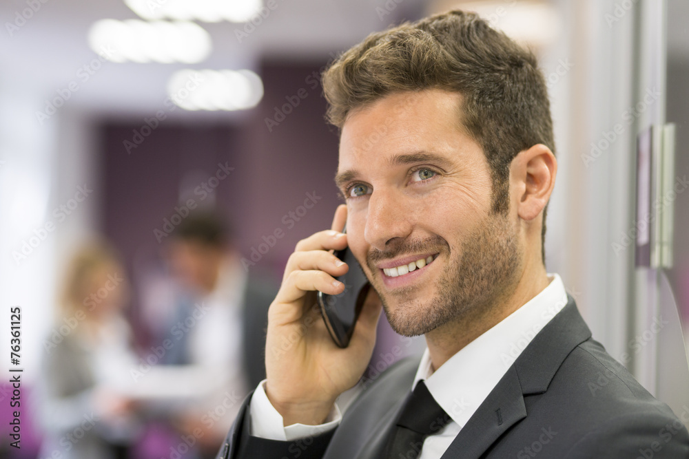 Handsome businessman on mobile phone in modern office Handsome businessman on mobile phone in modern office