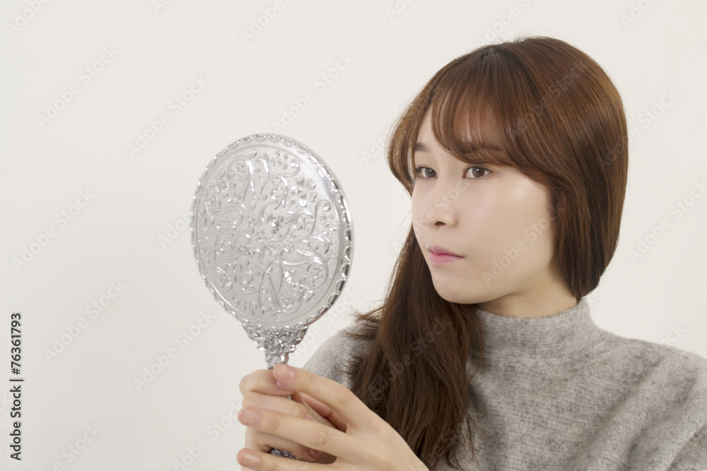 Pretty woman looking at herself in the mirror Pretty woman looking at herself in the mirror