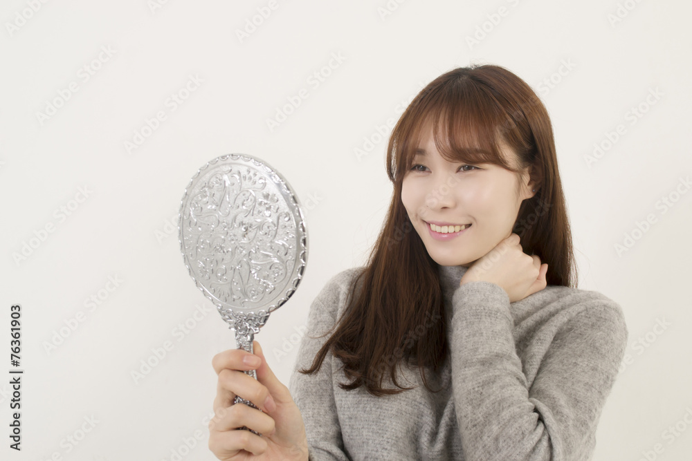 Pretty woman looking at herself in the mirror Pretty woman looking at herself in the mirror