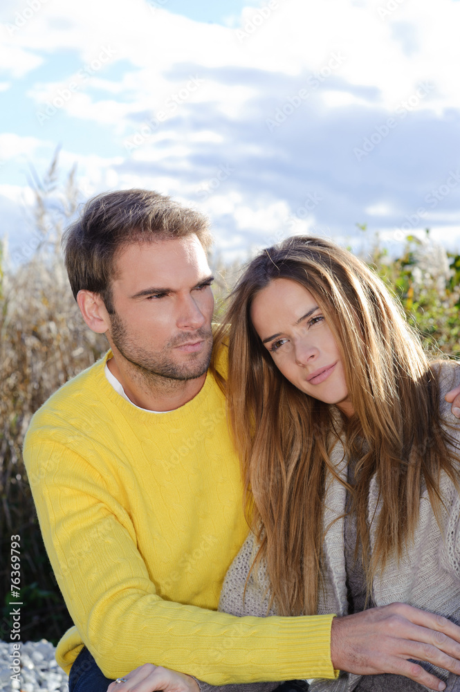 happy couple embracing and wearing warm clothes outside happy couple embracing and wearing warm clothes outside