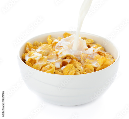 pouring milk into cornflakes bowl isolated on white