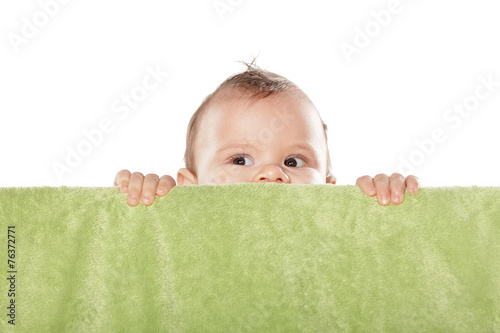 Photos cute baby boy peek behind the green towel