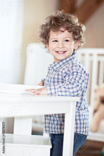 Happy, lovely baby boy in checked shirt smiling