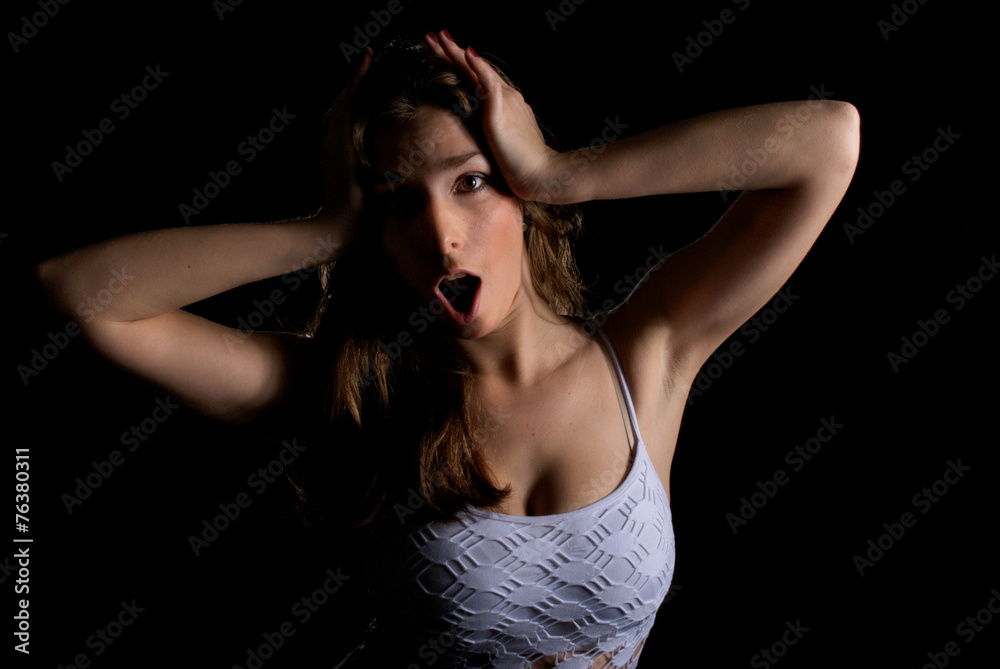 Surprised and shocked young woman Dramatic lowkey portrait. Surprised and shocked young woman Dramatic lowkey portrait.