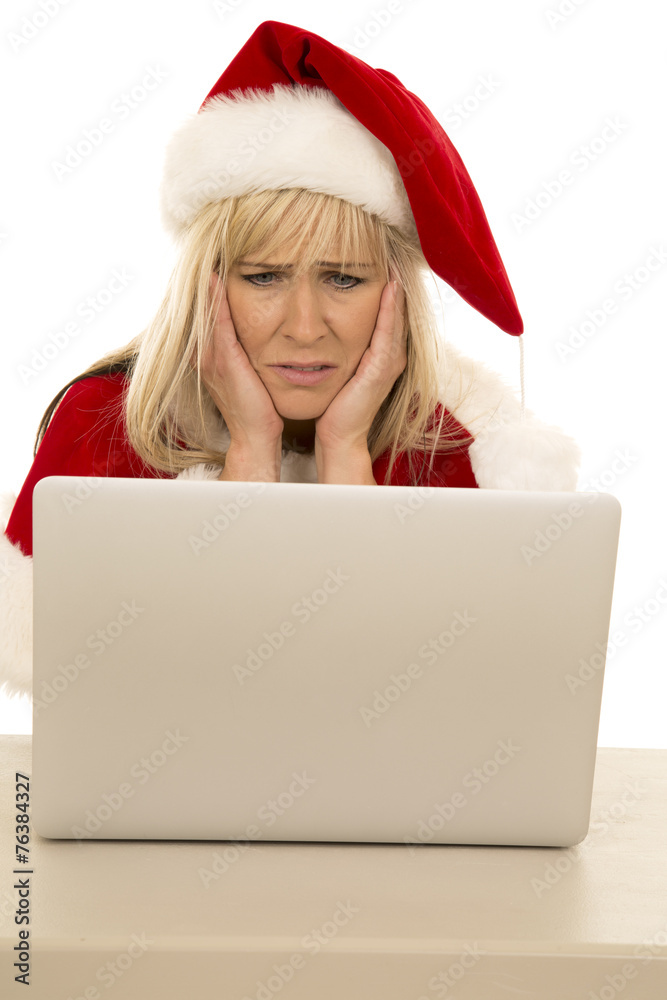woman in Santa hat with laptop hands on face woman in Santa hat with laptop hands on face