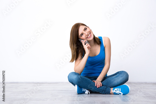 Young smiling woman talking on the phone and looking away