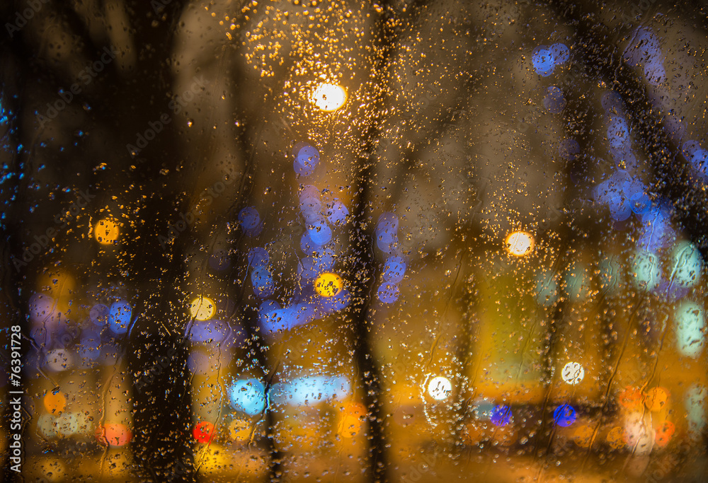 Wet  car window with the background of the night city lights