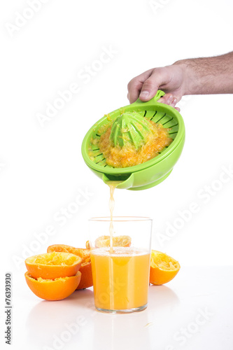 Preparing fresh orange juice squeezed with juicer