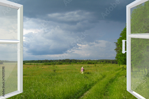 opened window to summer field before thunder