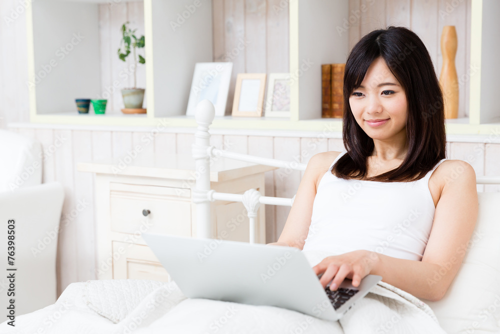 young asian woman using laptop in the bed room young asian woman using laptop in the bed room