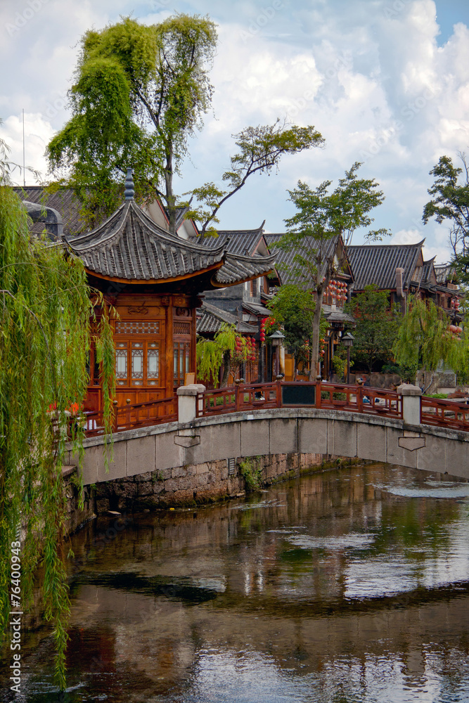 Wooden houes in Chinese style, picturesque bridge across the riv
