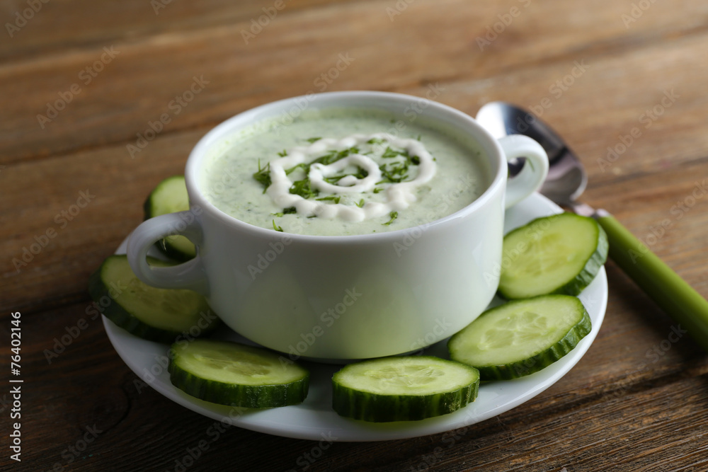 Cucumber soup in bowl on rustic wooden table background Cucumber soup in bowl on rustic wooden table background