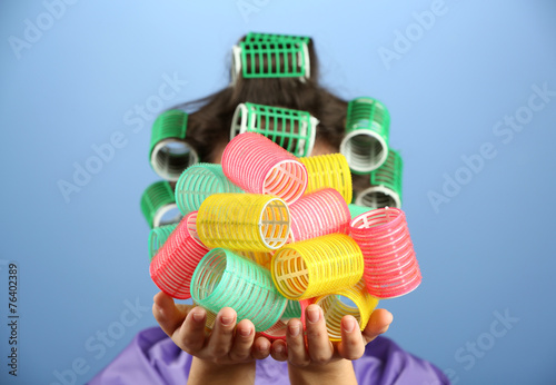 Girl in hair curlers on colorful background