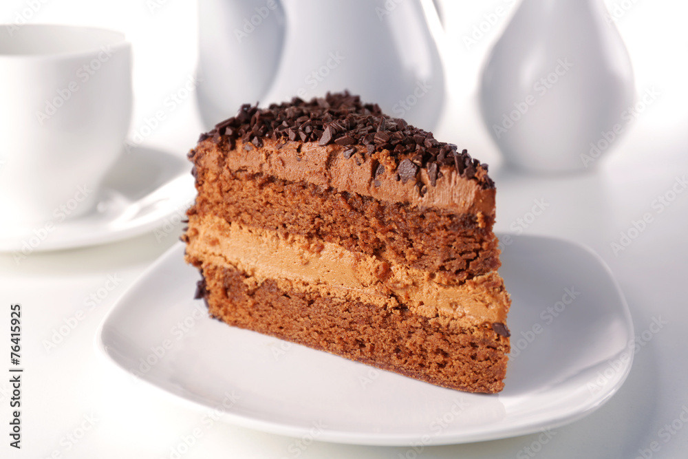 Delicious chocolate cake on plate on table on light background Delicious chocolate cake on plate on table on light background