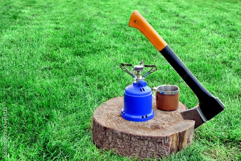 Lumberjack Axe, Gas Burner, Tea Mug on Tree Cross Section Lumberjack Axe, Gas Burner, Tea Mug on Tree Cross Section