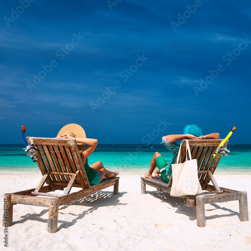 Couple in green relax on a beach at Maldives