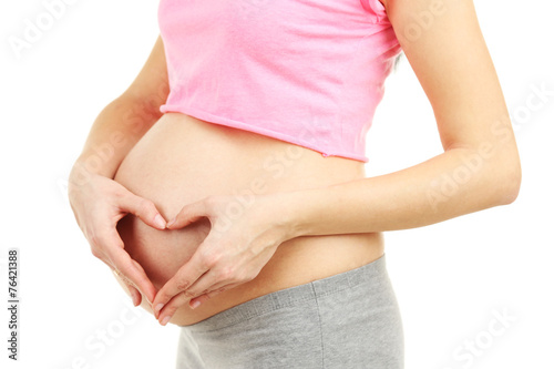 Beautiful young pregnant woman touching her belly isolated