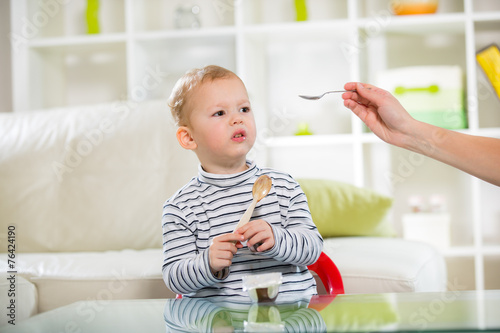 Two-years child himself eats with spoon