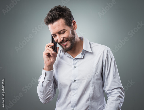 Smiling young businessman with smartphone