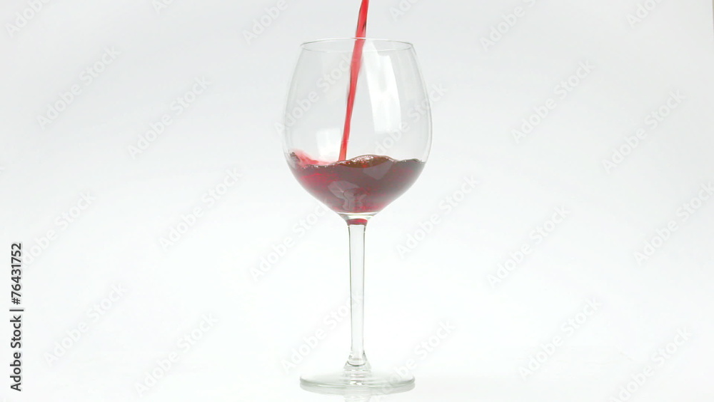 Red wine puoured in glass on white infinite background Red wine puoured in glass on white infinite background