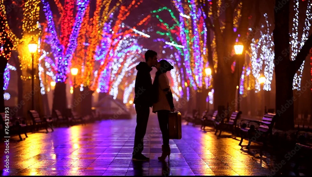 Couple with suitcase kissing at night alley. Couple with suitcase kissing at night alley.
