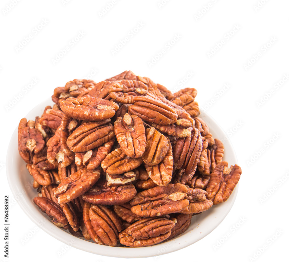 Pecan nut in a white bowl over white background Pecan nut in a white bowl over white background