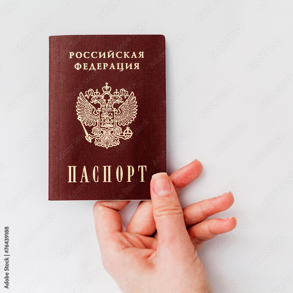 Russian passport in hand on a white background Russian passport in hand on a white background