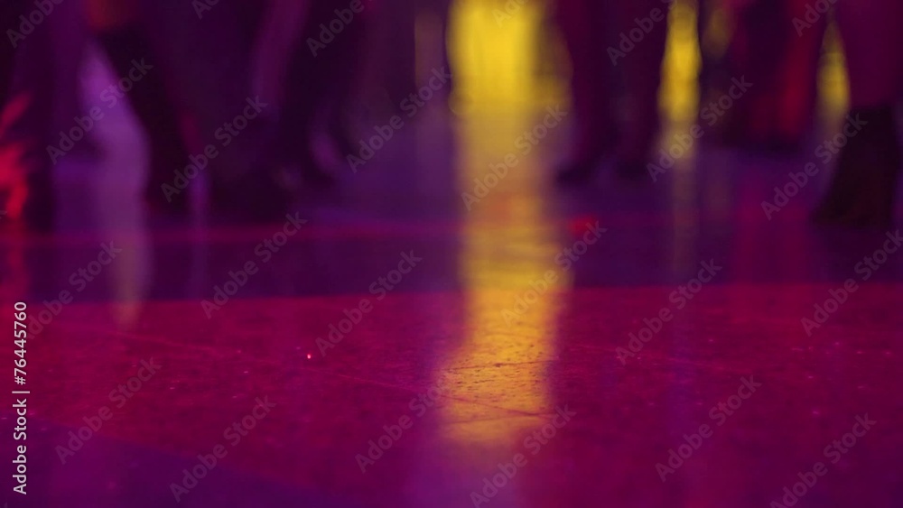 Dancing legs in spot lights rays lumiere on a disco