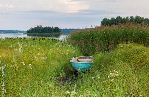 Fototapeta Naklejka Na Ścianę i Meble -  Old fishing boat at the lake in summer day