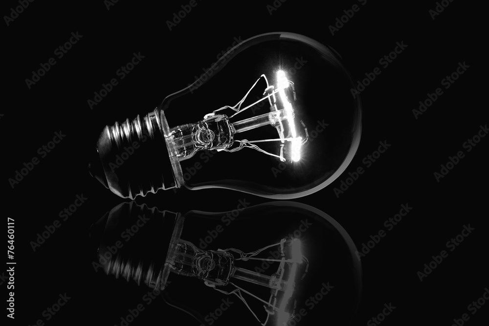 Light bulb and reflection isolated black background Light bulb and reflection isolated black background