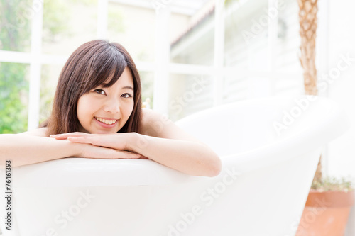 young asian woman relaxing in the bathtub