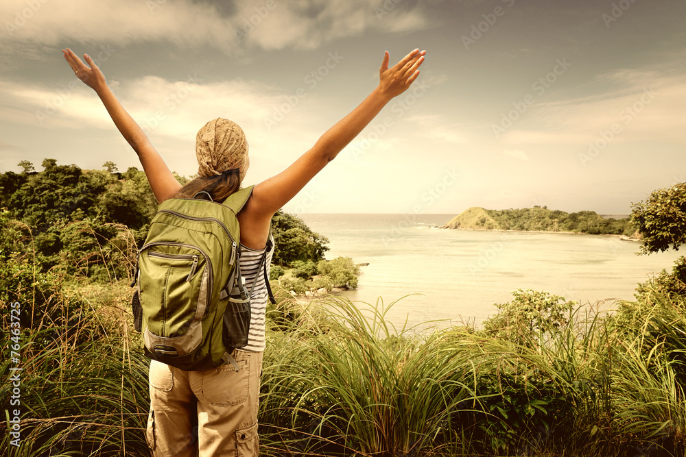 Hiker with backpack enjoying sea view from top of a mountain Hiker with backpack enjoying sea view from top of a mountain