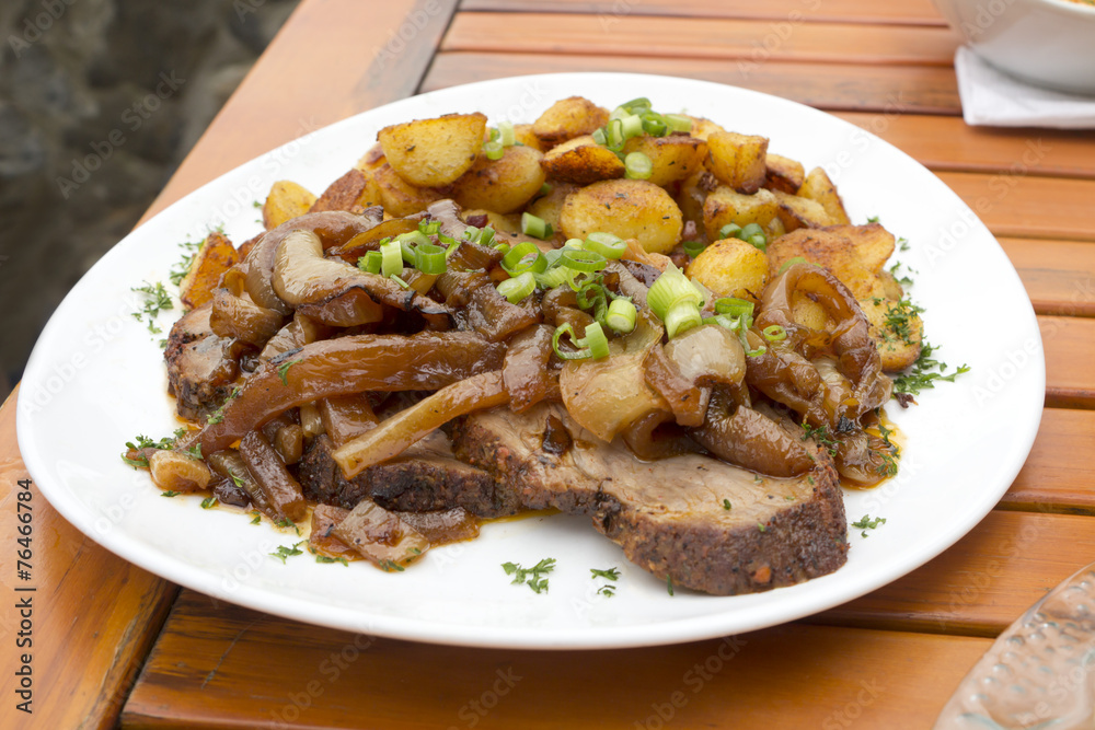Sauerbraten mit Schmorzwiebeln und Röstkartoffeln