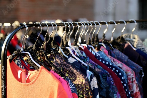 Many vintage style clothes  for sale at flea market photo