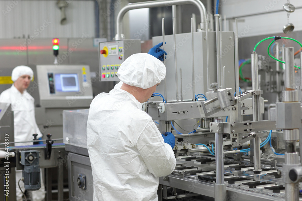 two workers in uniforms at production line in plant two workers in uniforms at production line in plant