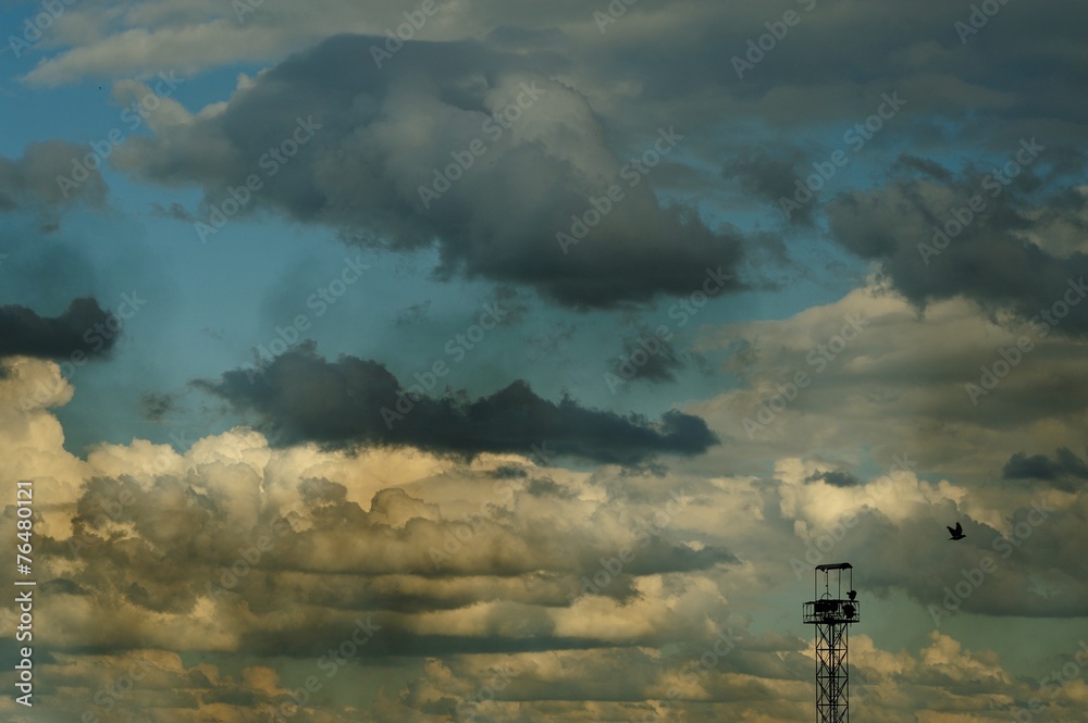 Summer cloudscape with blue sky, dirty smoke and steel tower