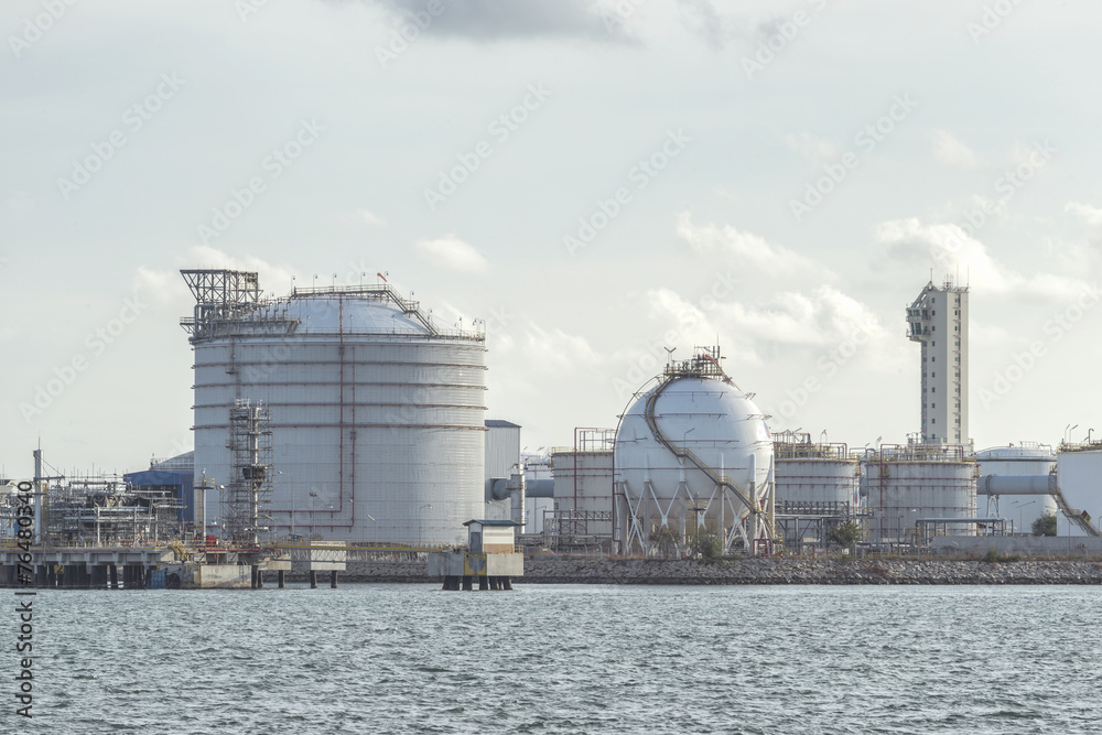 big Industrial oil tanks in a refinery with treatment pond at in
