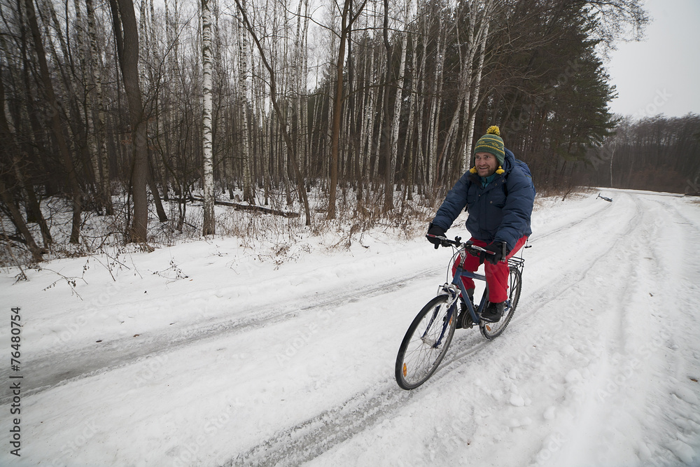 View of a cyclist in winter forest