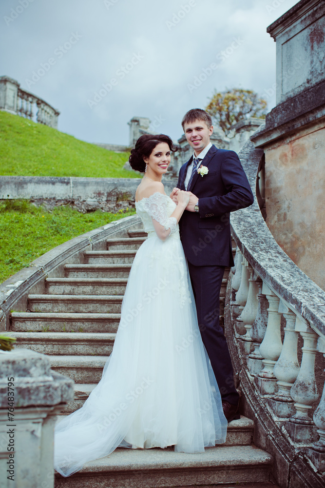 Beautiful bride and groom stay on stairs among mountain landscap Beautiful bride and groom stay on stairs among mountain landscap
