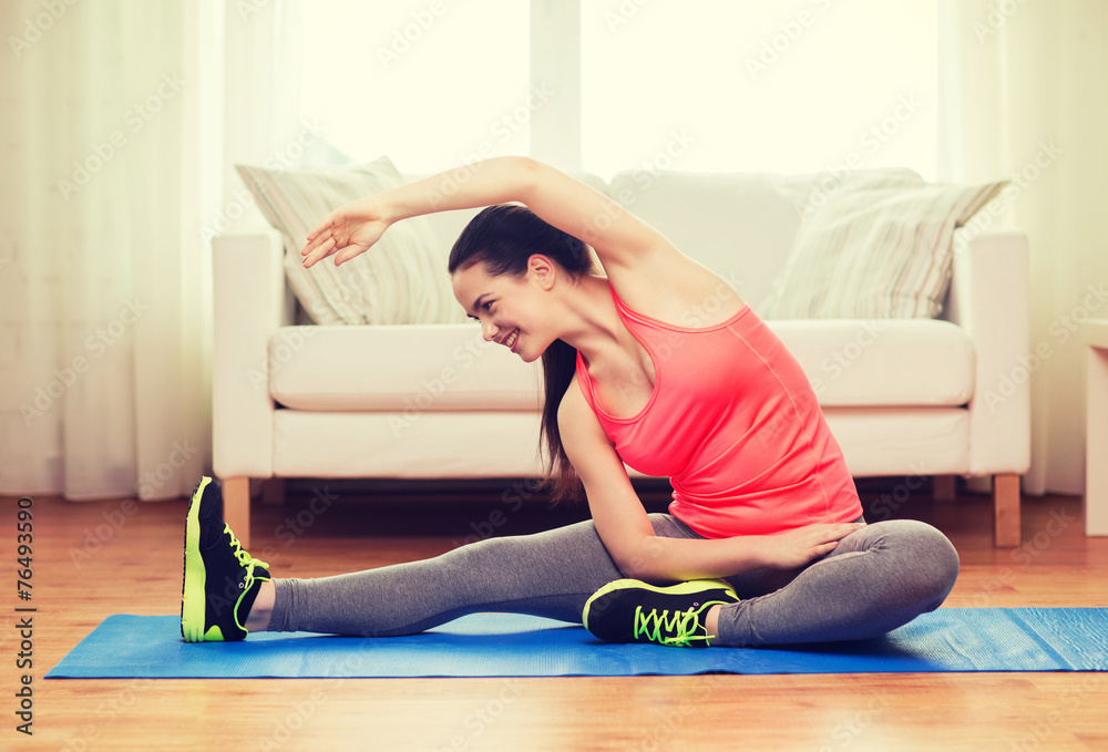 smiling teenage girl streching on floor at home smiling teenage girl streching on floor at home