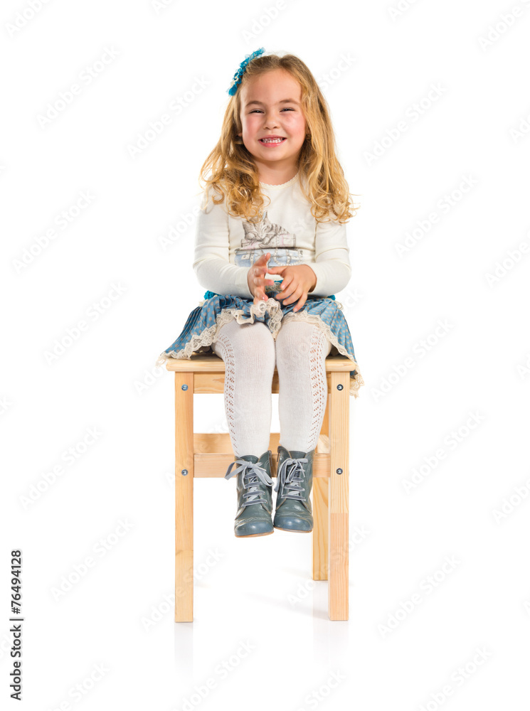 Little blonde girl sitting on chair