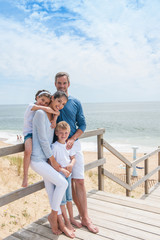 happy family  standing on a wood pontoon in front of the sea in