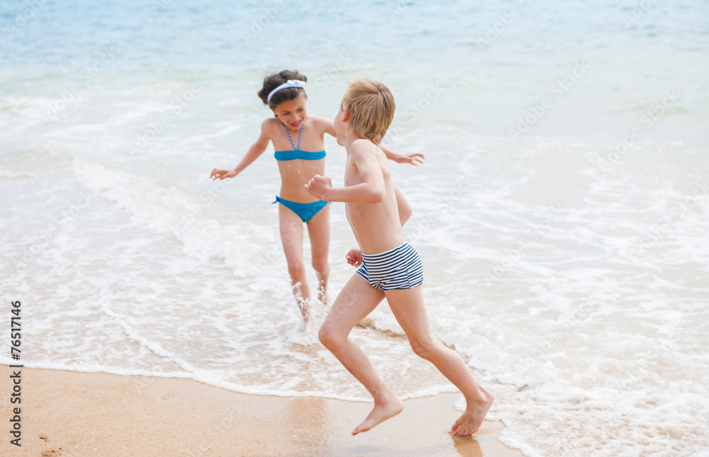 A boy and a girl are playing in the sea waves A boy and a girl are playing in the sea waves