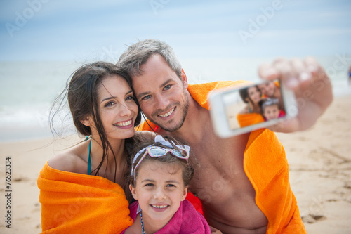 A young couple and their daughter taking a selfie