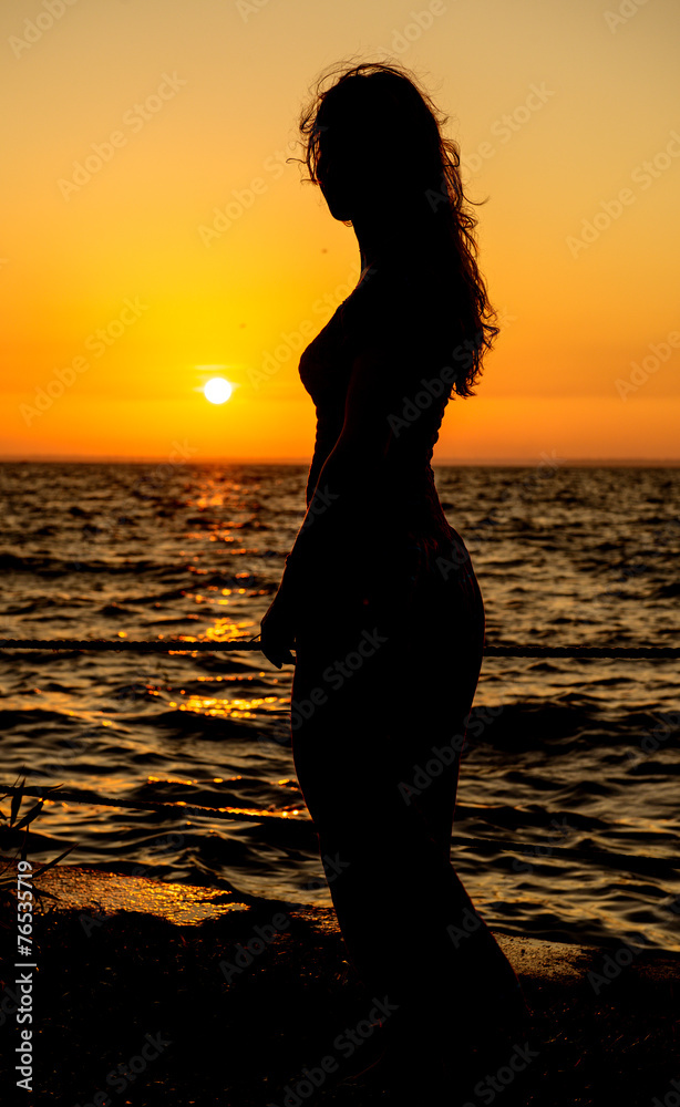 silhouette of a girl at sunset profile position