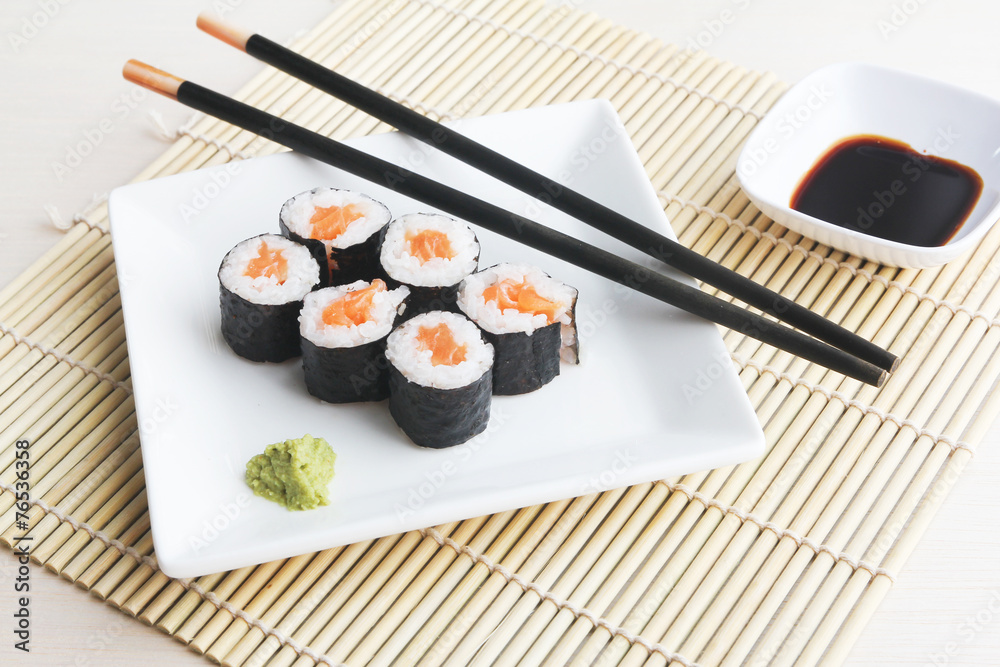 Plate of salmon sushi maki on bamboo mat Plate of salmon sushi maki on bamboo mat