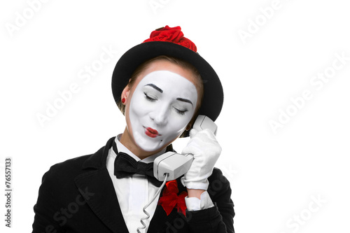 Woman in the image mime holding a handset.