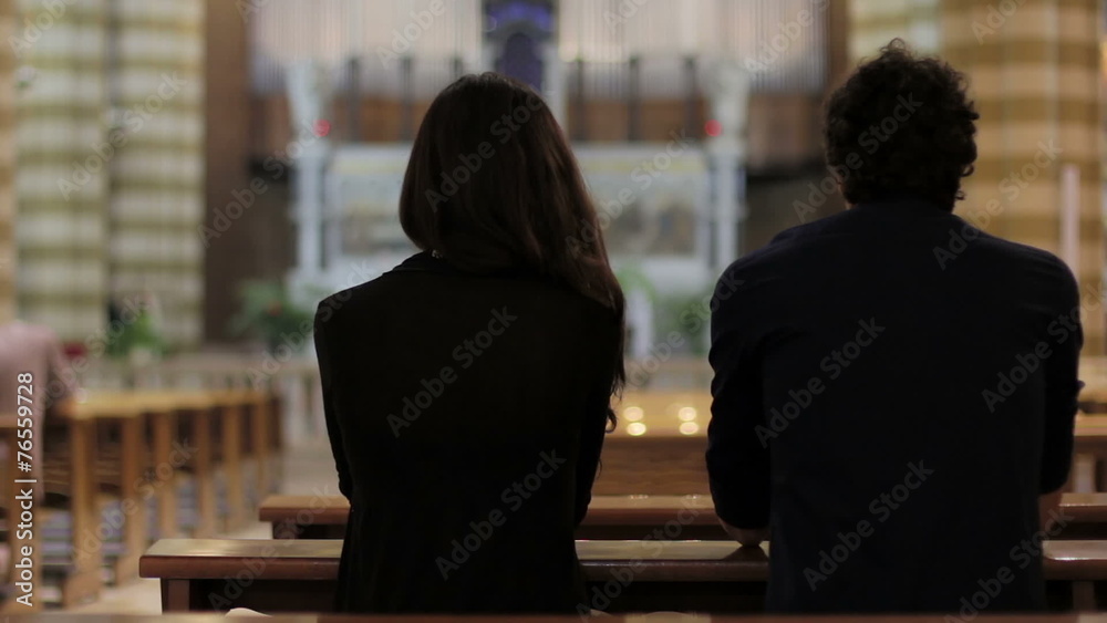 a man and a woman praying in a church a man and a woman praying in a church